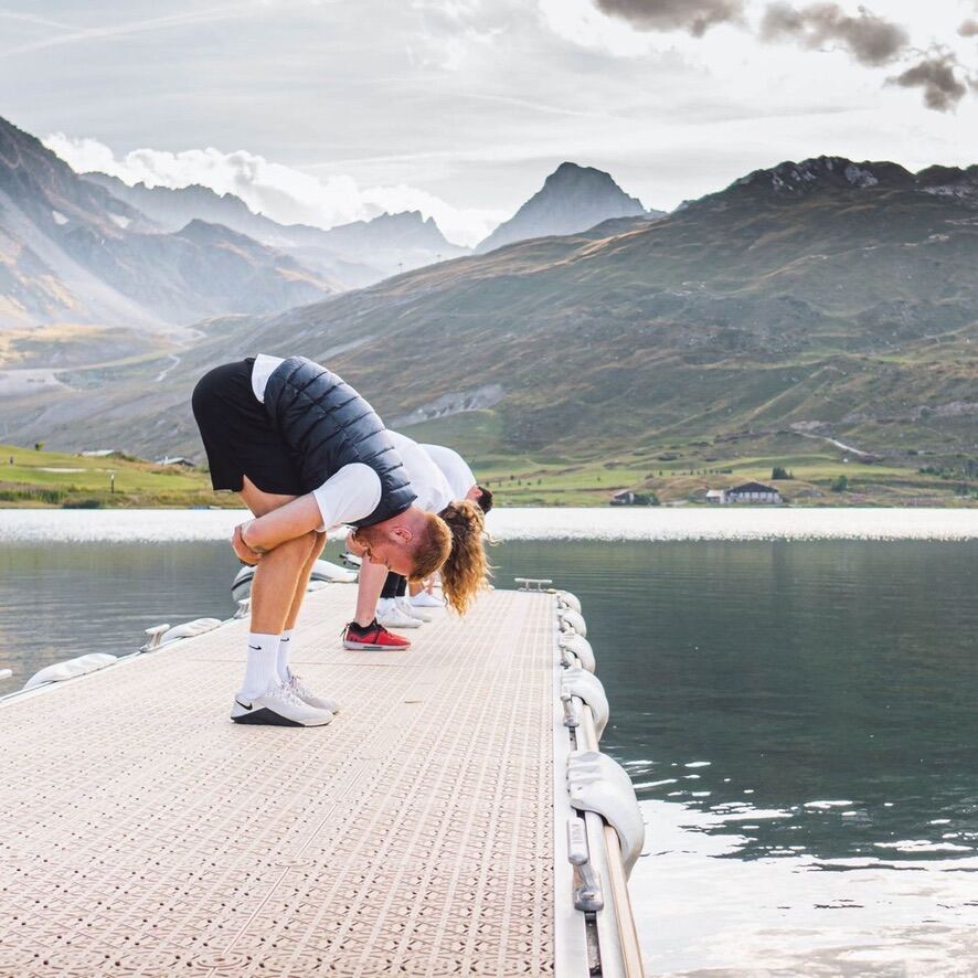 Athlete stretching on a lake dock in the mountains