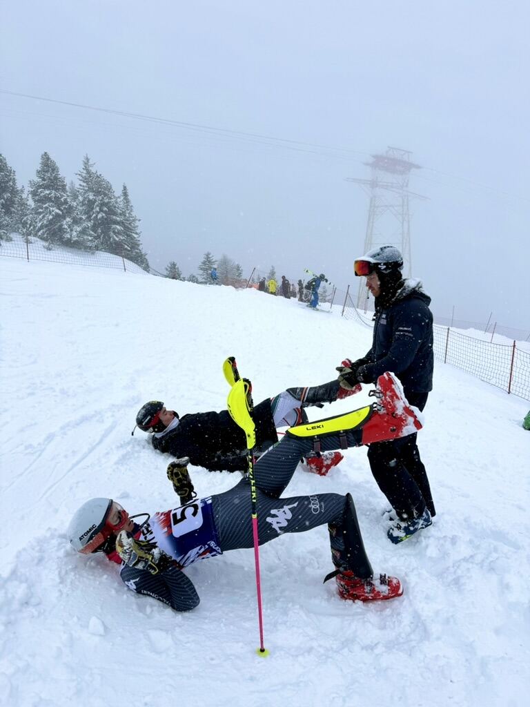 Coaches with a ski racer on the training slope